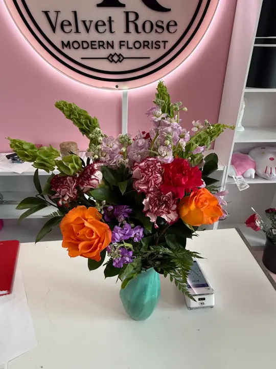 Fresh orange rose vase arrangement inside Velvet Rose