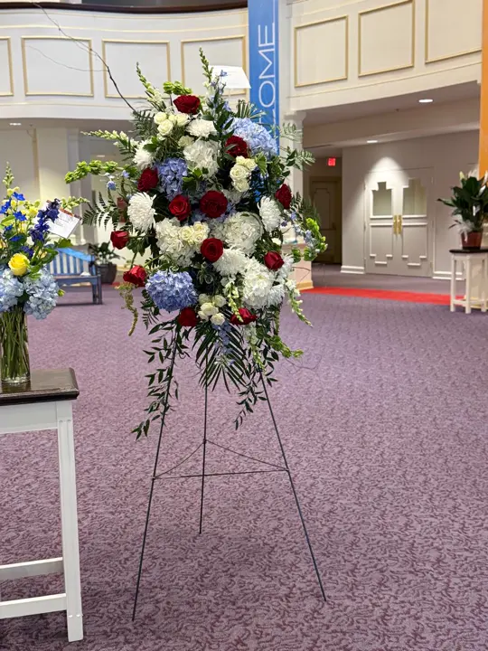 Red white and blue funeral standing spray at a Nashville service