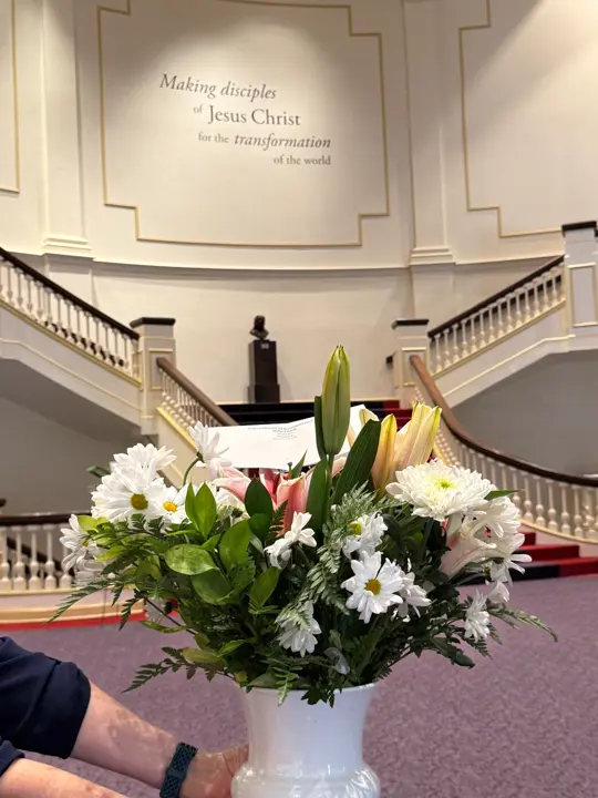 White sympathy vase arrangement inside a church
